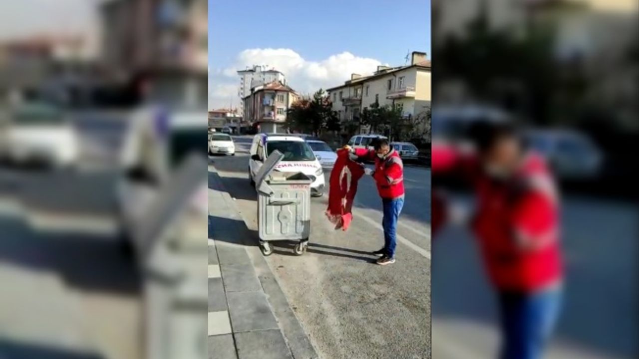 Çöpte gördüğü Türk bayrağını temizledikten sonra aracına aldı